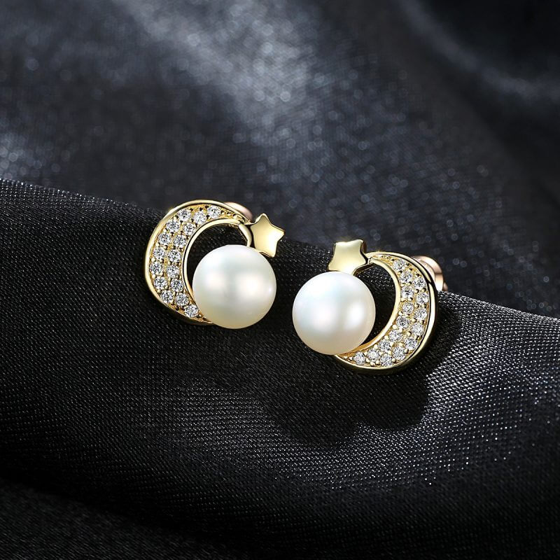 сребърни обеци с перла и златно покритие, снимка на черен фон