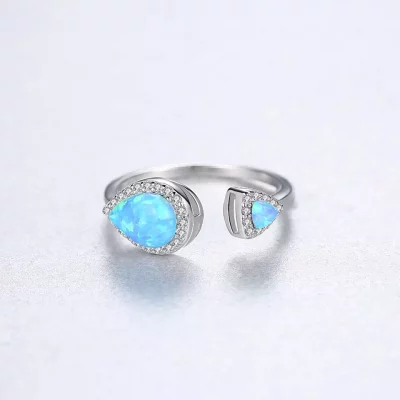 сребърен пръстен със син скъпоценен камък, снимка на сив фон