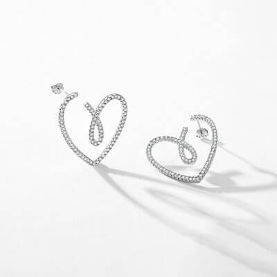 сребърни обеци във формата на сърце, снимка на сив фон